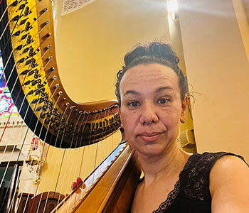 Photo of Aja playing harp