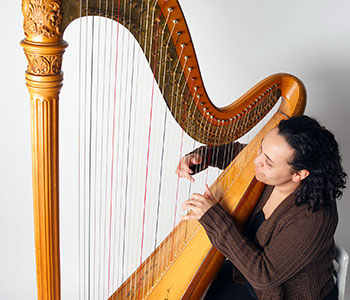 Photo of Aja playing harp