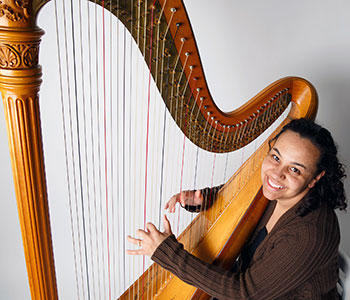 Photo of Aja playing harp