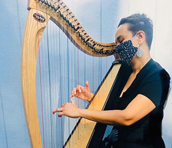 Photo of Aja playing harp