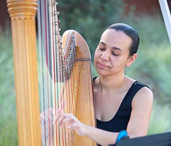 Photo of Aja playing harp