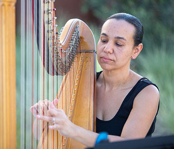 Photo of Aja playing harp