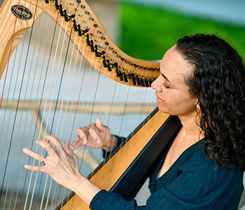 Photo of Aja playing harp