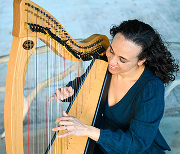 Photo of Aja playing harp